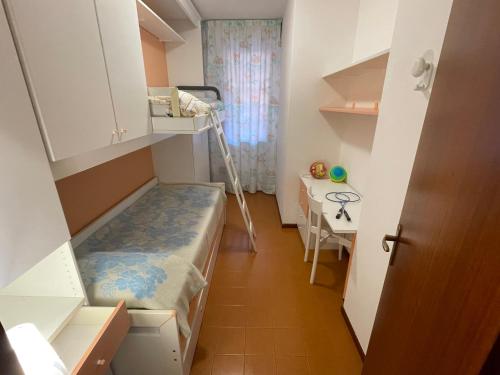 a small room with a bunk bed and a desk at Residence Solarium Qua in Bibione