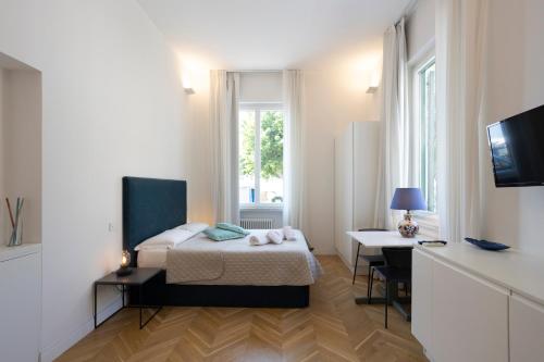 een slaapkamer met een bed, een bureau en een raam bij SINONDA Luxury Apartment in Maiori