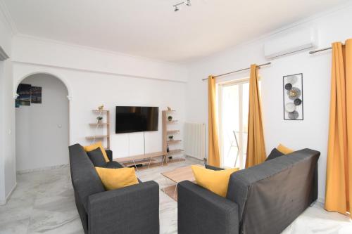 a living room with two chairs and a tv at Levante Breeze in Xirokástellon