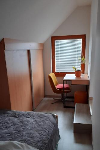 a bedroom with a bed and a table and a chair at Apartment Pr Dev in Begunje na Gorenjskem