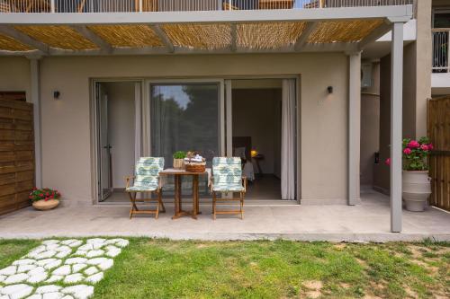 a patio with a table and two chairs on it at Forest Resort Suites Skiathos in Troulos