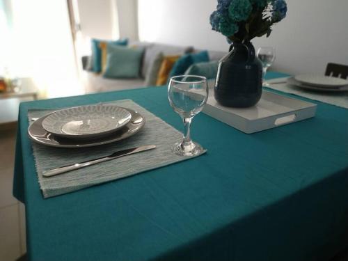 einen Tisch mit einem Teller und einem Weinglas darauf in der Unterkunft StelisIoanna in Chania