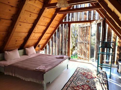 - une chambre avec un lit et une grande fenêtre dans l'établissement Verde de Viscri, à Viscri