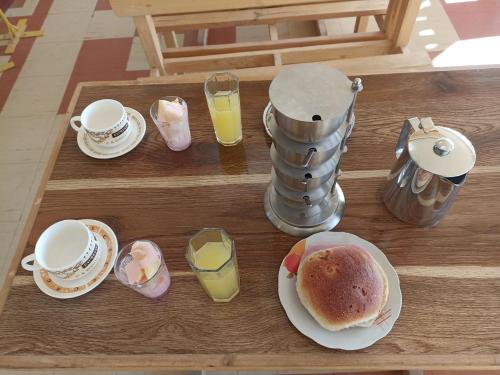 科帕卡巴納的住宿－H.Espejo，桌子,上面有杯子和盘子,食物和饮料