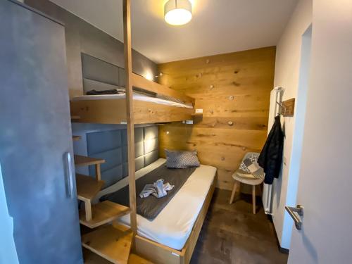 a small room with a bed and bunk beds at Lago Lodge Claudia in Domaso