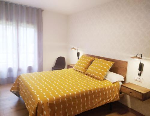 - une chambre avec un lit jaune et une chaise dans l'établissement Apartamento Tubal, à Bossost