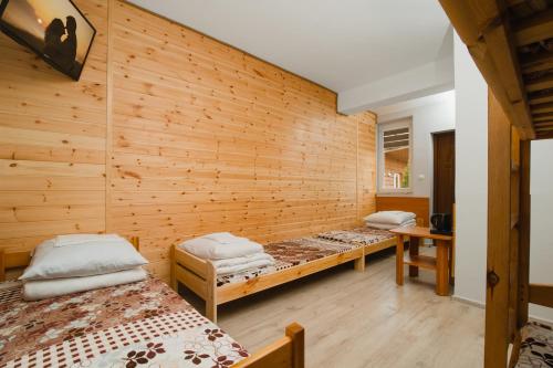 ステグナにあるOśrodek Wypoczynkowy Syrenkaのベッド2台 木製の壁の部屋