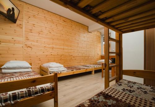 ステグナにあるOśrodek Wypoczynkowy Syrenkaの木製の壁にベッド3台が備わる部屋