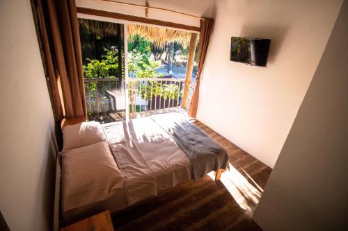 een slaapkamer met een bed en een groot raam bij Kali Village in Acapulco