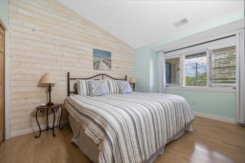 a bedroom with a bed with a wooden wall at Beachside 329 Waterfront Condo in Traverse City