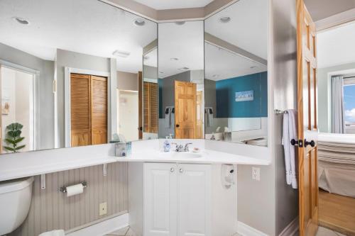 a bathroom with a sink and a toilet and a mirror at Beachside 329 Waterfront Condo in Traverse City