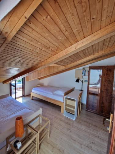een slaapkamer met 2 bedden en een houten plafond bij Apartments Dara in Rogoznica