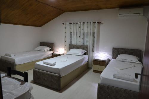 a bedroom with two beds and two tables and two chairs at Guest House Bumbli in Berat