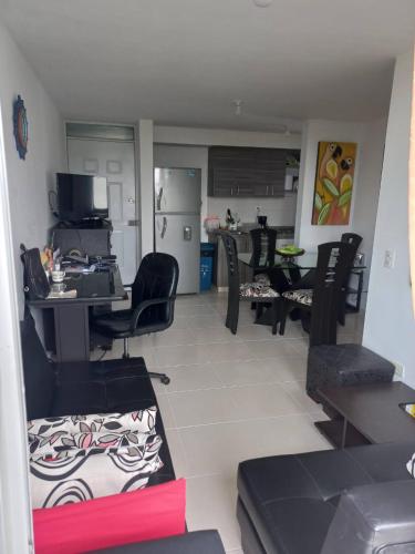 sala de estar con sillas negras y cocina en Apartamento hogareño, en Pereira