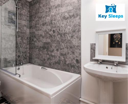 a bathroom with a sink and a bath tub and a mirror at Key Sleeps- Spacious - Contractor House - Central Location - Garden - Lincolnshire in Lincolnshire