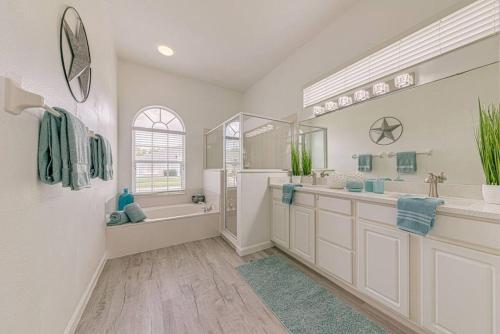 a bathroom with a tub and a shower and a sink at 596 Modern 5 bed home overlooking beautiful golf course and conservation with Games room in Davenport