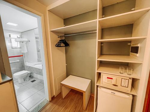 a small bathroom with a walk in closet with a toilet at St Paul Plaza Hotel in Brasilia
