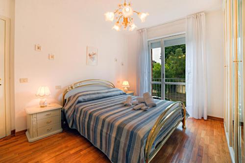 een slaapkamer met een bed, een raam en een kroonluchter bij Roger's Apartment in Siena