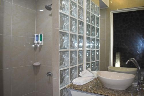 a bathroom with a sink and a shower with a sink at Hotel Mar de Luz in Jacó