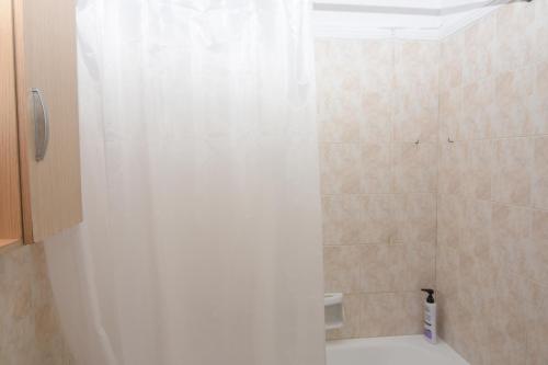 a bathroom with a shower with a white curtain at Levante Breeze in Xirokástellon