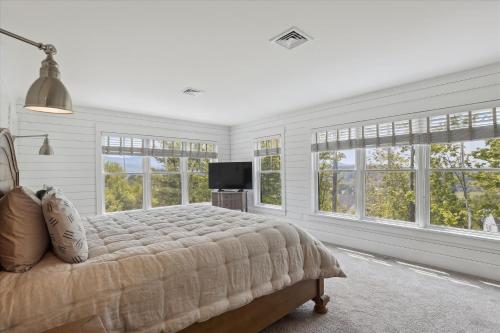 a bedroom with a bed and a tv and windows at Francis Lane in Stowe