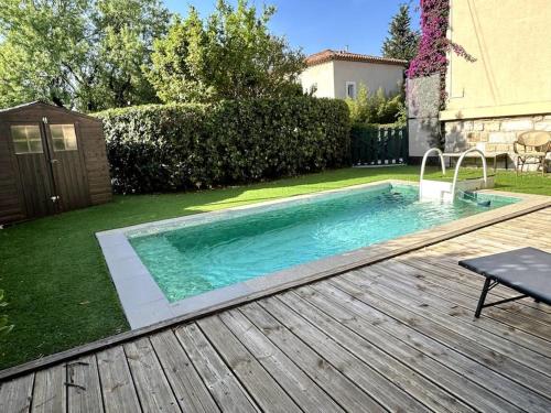 - une piscine dans une cour avec une terrasse en bois dans l'établissement En toute intimité, à Toulon