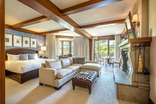a bedroom with a bed and a couch and a fireplace at Hotel Quintessence in Mont-Tremblant