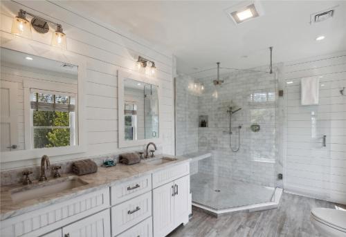a white bathroom with two sinks and a shower at Francis Lane in Stowe
