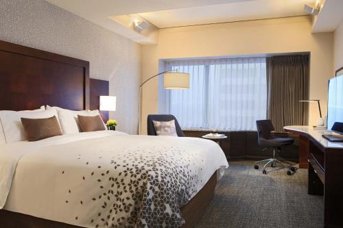Pokój hotelowy z dużym łóżkiem i biurkiem w obiekcie Renaissance Seattle Hotel w mieście Seattle