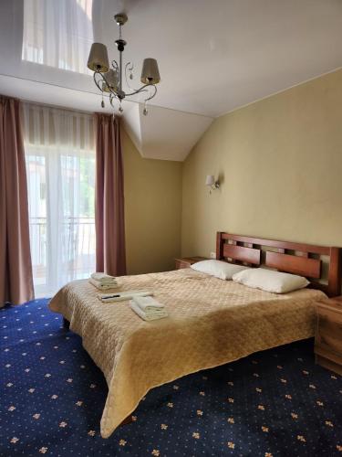 a bedroom with a large bed and a large window at Вiлла Тераса in Polyana