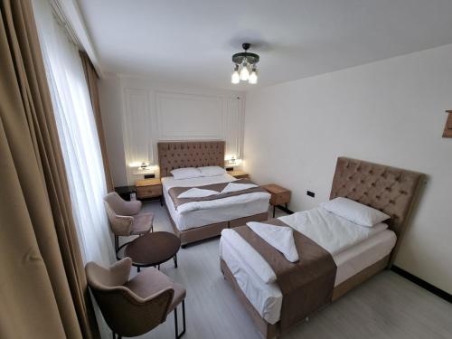 a hotel room with two beds and a table and chairs at Elite Park Hotel & Suites in Beylikduzu