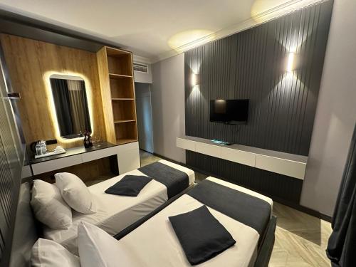 um quarto de hotel com duas camas e uma televisão em Bel Mare Boutique Hotel em Batumi