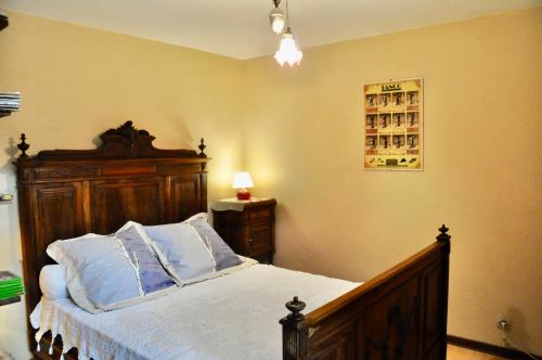 a bedroom with a bed with a wooden headboard at CHEZ LUCIEN in Trébas