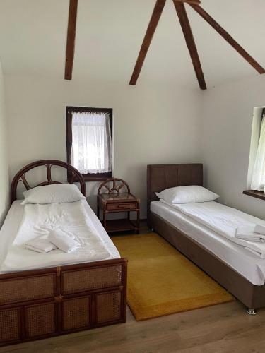 two beds in a room with two windows at Apartment with river Una view / Ilma 2 in Bihać