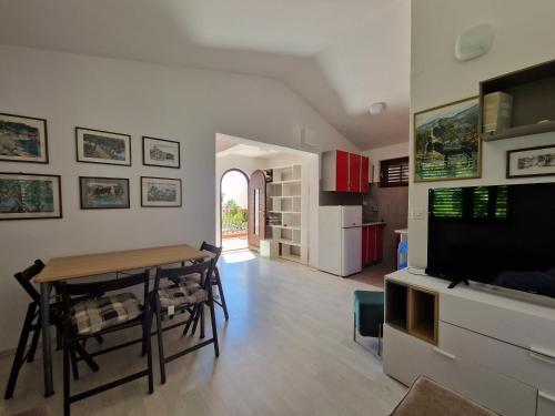 een keuken en een woonkamer met een tafel en een televisie bij Apartments Dara in Rogoznica