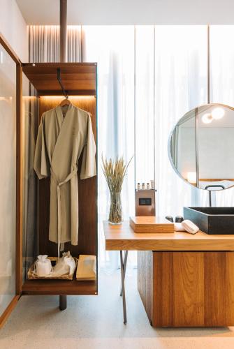 a dressing room with a desk and a coat on a rack at 了了礁溪 Vivir Jiaoxi Hotel in Jiaoxi