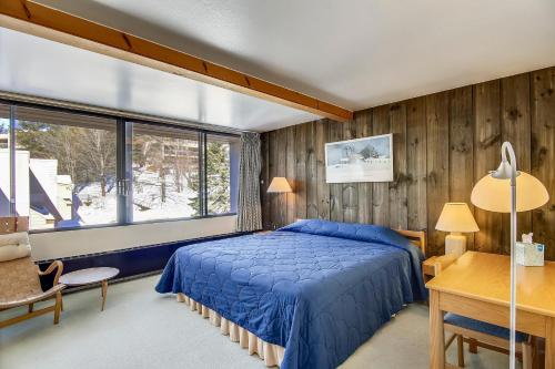 a bedroom with a blue bed and a window at Notchbrook 28AB in Stowe