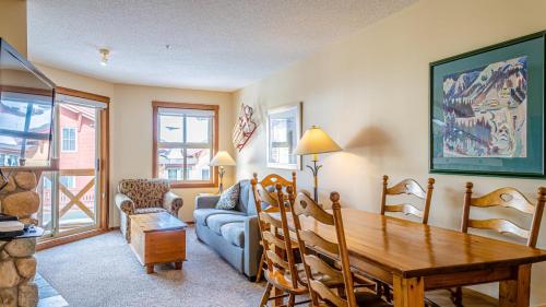 a living room with a table and a couch at Fireside Lodge #315 By Bear Country in Sun Peaks