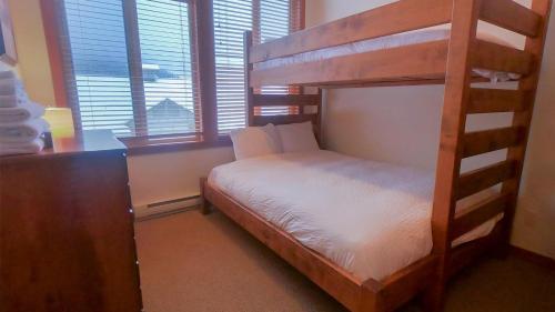 a bedroom with a bunk bed in a room with windows at Settlers Crossing #29 By Bear Country in Sun Peaks
