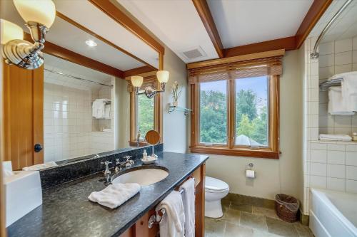 a bathroom with a sink and a toilet and a window at Trapp Villa 29 in Stowe