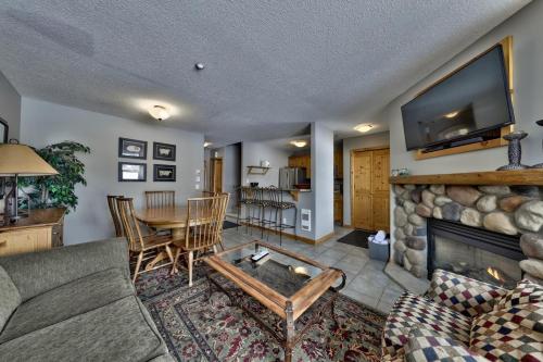 a living room with a couch and a table and a fireplace at Crystal Forest #40 By Bear Country in Sun Peaks