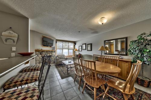 a kitchen and living room with a wooden table and chairs at Crystal Forest #40 By Bear Country in Sun Peaks