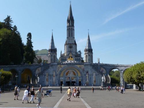 a group of people walking in front of a building at Hotel Du Gave in Lourdes