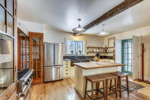 a kitchen with a stainless steel refrigerator and wooden floors at The Cozy Villager in Stowe