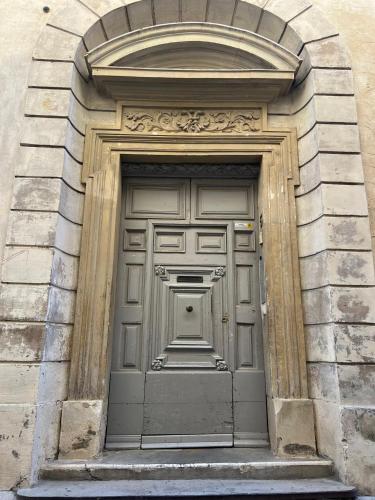 une grande porte dans un bâtiment avec une arche dans l'établissement N°5 - Appartement avec jardin au cœur de l'hypercentre, à Arles