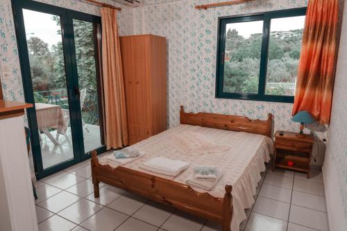een slaapkamer met een bed in een kamer met ramen bij Viki Studios in Pefki