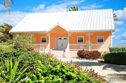 a small orange house with a white roof at Cayman Dream by Grand Cayman Villas & Condos in Driftwood Village
