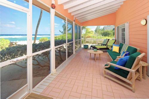 a screened in porch with chairs and a view of the ocean at Cayman Dream by Grand Cayman Villas & Condos in Driftwood Village