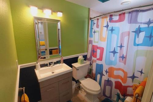 a bathroom with a sink and a toilet and a shower curtain at Itz a Vibe - 1 bedroom studio in the heart of DTSP in St Petersburg