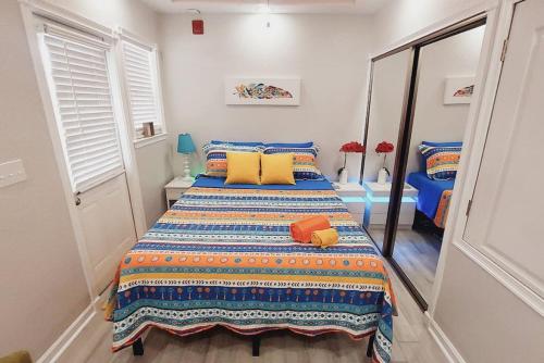 a bedroom with a bed with blue and yellow pillows at Itz a Vibe - 1 bedroom studio in the heart of DTSP in St Petersburg